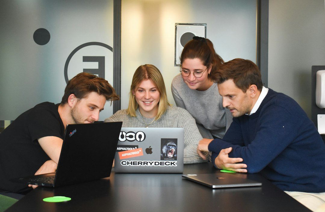 Team collaborating around a laptop in a modern office